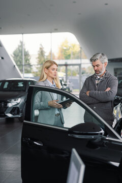 Professional car dealer consulting customer modern auto stor 