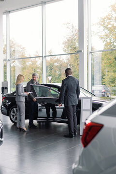 Car store professionals presents vehicle potential buyer
