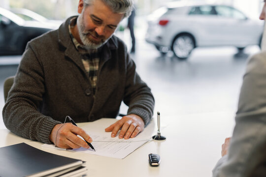 Client signing agreement car dealership automotive industry