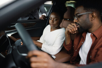 Young customers cheking car together automotive industry