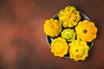 Pattypan zucchini on a textured kitchen table. squash. Fresh organic pattypan squashes on...