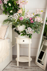 flowers in a vase in a bright room with a bed