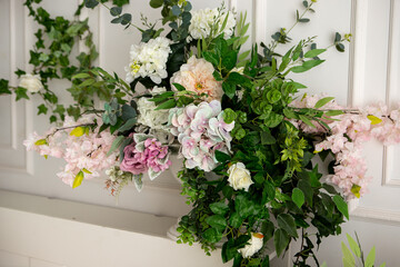 flowers in a vase in a bright room with a bed