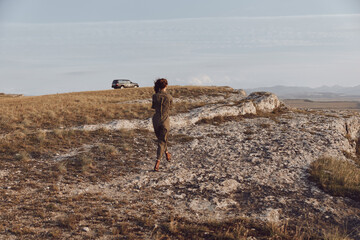 Exploring the majestic mountain person walking on hill with car in background, nature travel adventure concept © SHOTPRIME STUDIO