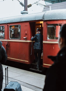 Conductor in classic vintage uniform waiting for deprture of train