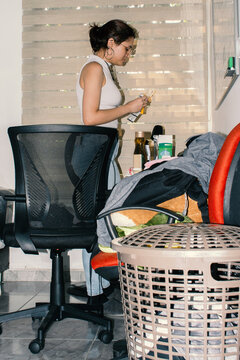 Young Woman Organizing Room and Sorting Bills