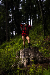 street portrait of a beautiful young brunette girl in a hat. Bright daylight, into the woods
