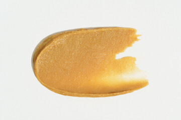 Smudge texture of peanut butter paste on white isolated background. Concept of nutritious breakfast, snack. Background for your deign