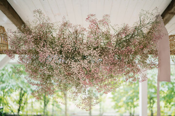 Hanging floral arrangement with pastel hues in background