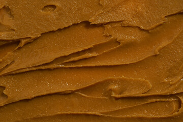 A smear of creamy peanut butter close-up. The concept of breakfast, nut paste