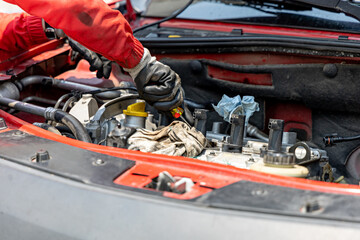 Close-up of the gloved hands of a mechanic using a screwdriver