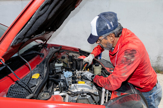 Adult man showcasing his mechanical skills, repairing his own car