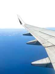 Looking out of an airline window at the wing as the plane flies over a large body of water. The sky...