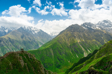 Fototapeta premium A lonely bench on an observation deck above a steep cliff with a picturesque view of the beautiful mountains