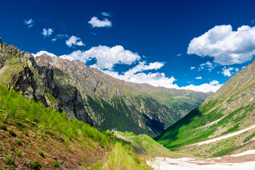 High picturesque green mountains with the remains of melting snow in the mountains of the North Caucasus. Russia