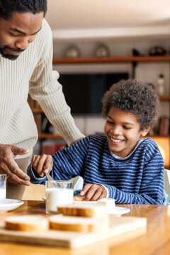 Father with happy son having breakfast at home
