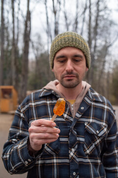 Man in the woods enjoying typical Canadian maple taffy