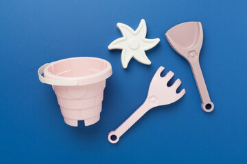 Cute toys for playing with sand on color background, top view