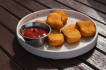 Close up of deep fried chicken nuggets on a wooden background.