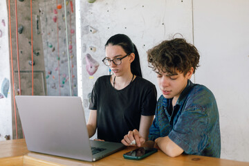  Friends Working Together on a Laptop Computer in Climbing Gym