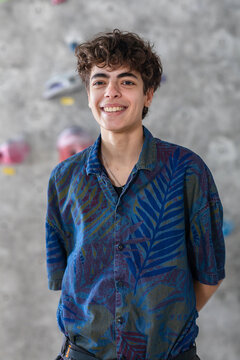 Smiling Curly Young Man at Indoor Rock Climbing Gym