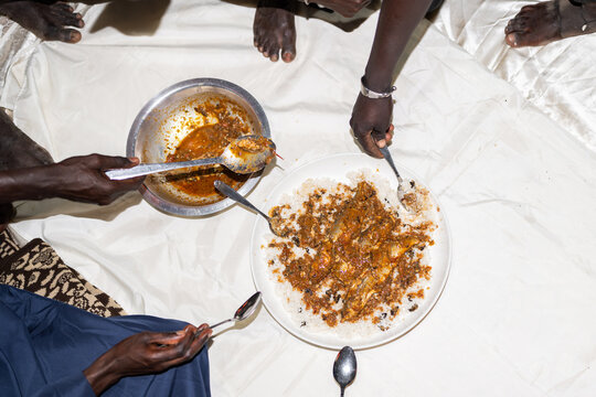 People eating a traditional senegalese meal together sharing food