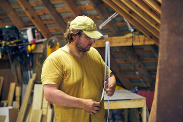 a man in a home carpentry shop selects boards for work