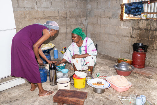 Two women are preparing a traditional senegalese meal in a kitchen