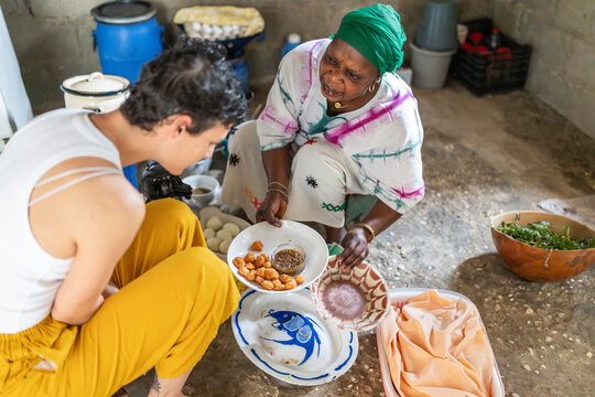Senegalese woman showing local food to a travel blogger in africa