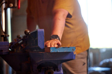 man sawing wood on a jointer in a home workshop