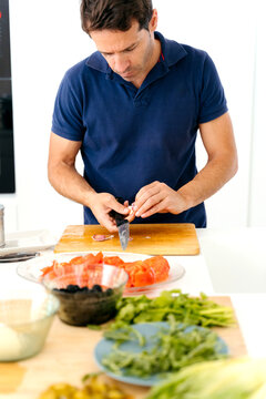 Man slicing garlic in Kitchen