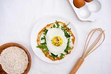  Pancake with eggs, cream cheese, arugula, spatula, oatmeal for healthy breakfast on white background top view.