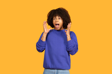 A guy with curly hair displays a surprised expression while raising his hands in a dramatic gesture. The yellow background adds a cheerful atmosphere, enhancing the emotional impact of the moment