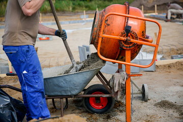 Constriction worker making concrete in an orange mixer