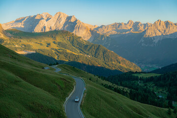 Car on winding road through Alps