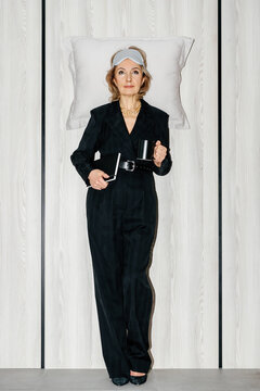 Businesswoman standing with pillow and sleep mask