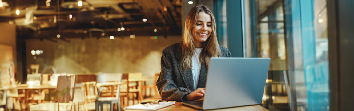 Stylish woman manager freelancer working on laptop while sitting in cozy cafe. High quality photo