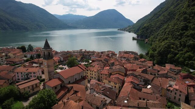 Aerial view of Porlezza village on Lugano lake shore at Italy Switzerland border. Scenic Lombardy mountain landscape. Italian lake district travel destination, 4k video.