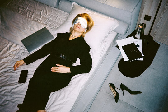 Tired businesswoman on bed after hard work day