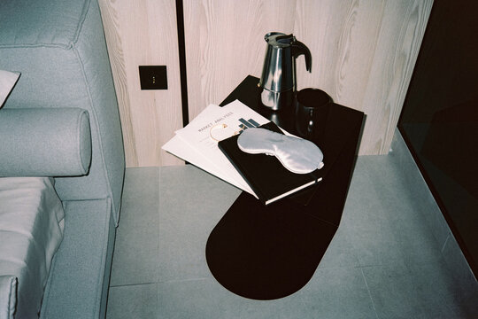 Black bedside table with documents and coffee