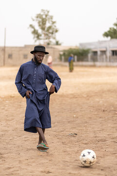 Young stylish african man is walking on a dusty field