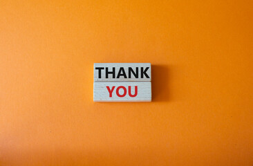 Thank you symbol. Wooden blocks with words Thank you. Beautiful orange background. Business and Thank you concept. Copy space.