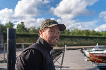 a blond man at the marina in copenhagen admiring the boats