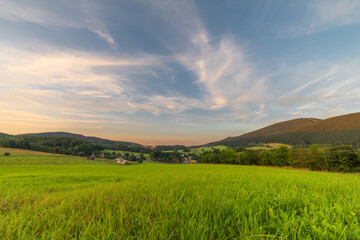 Green meadow with hills and fresh forests near Ramzova village