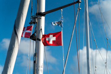 Fototapeta premium yacht in the harbor with danish flag waving on a blue sky