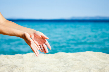 A hands pouring sand near the seashore on weekend nature travel