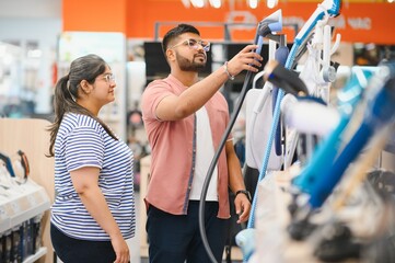 An Indian couple chooses an iron steamer in an electronics store