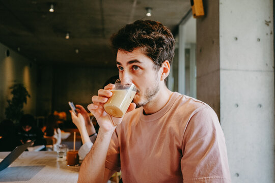 Male drinking iced coffee, in the cafeteria