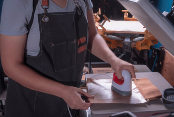 Working woman in her workshop doing the sublimation process with a heat press.