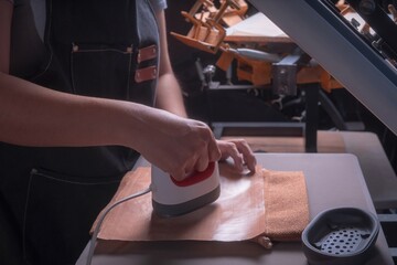 Working woman in her workshop doing the sublimation process with a heat press.
